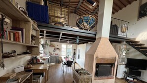 A spacious kitchen with a large wooden table, a built-in oven, and a dining area with chairs.