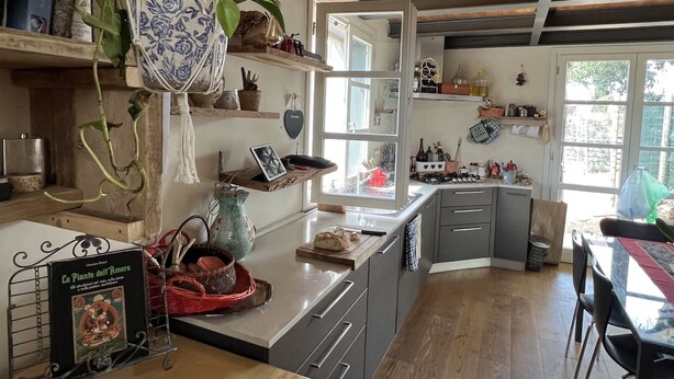 A kitchen with wooden cabinets, a countertop, and various kitchen items.