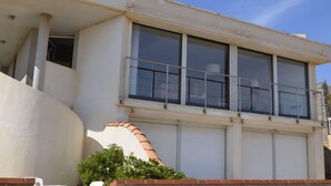 A building with a flat facade, large windows, and a balcony with metal railings. - Beach house facing the sea (Valras-Plage)