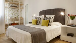 A neatly arranged bedroom with a bed, bedside tables, a nightstand, and a built-in shelving unit. - 3Dorm / 3bathroom Apt-Gran Via Madrid Center-Terrace (Madrid)