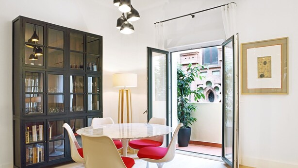 A dining area with a round table, white chairs, and a dark wooden cabinet with glass doors. - 3Dorm / 3bathroom Apt-Gran Via Madrid Center-Terrace (Madrid)