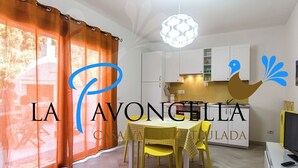 A modern kitchen with white cabinets, a yellow table, and a checkered tablecloth.