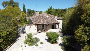 A stone house with a tiled roof, surrounded by greenery and a paved courtyard. - Beautiful Old Bastide with private pool and heated Nordic bath, near Montcuq (Montcuq-En-Quercy-Blanc)
