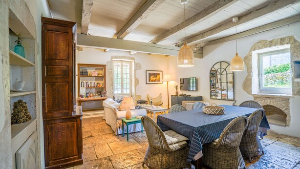 A rustic dining room with a large wooden cabinet, wicker chairs, a dining table with a polka dot tablecloth, and a stone fireplace. - Beautiful Old Bastide with private pool and heated Nordic bath, near Montcuq (Montcuq-En-Quercy-Blanc)
