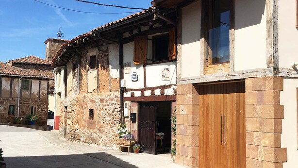 Un bâtiment traditionnel en pierre, doté d’une porte en bois et d’une enseigne indiquant qu’il s’agit d’une maison d’hôtes.