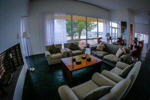 Un salón amplio con un ventanal grande, una chimenea y una mesa de centro.