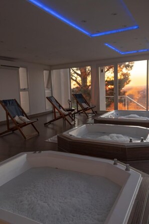 Un cuarto de spa con dos tinas de hidromasaje y sillones de descanso.