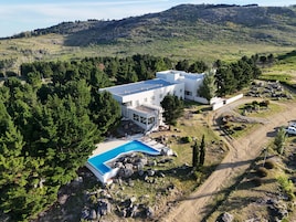 Una casa moderna con piscina rodeada de árboles.