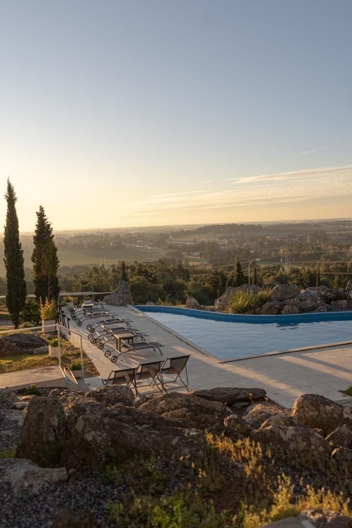 Area piscina con lettini e vista sul paesaggio.