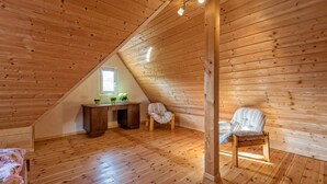 A wooden attic room with a sloped ceiling, a desk with two chairs, and a bed. - Exclusive Country house Seewald - quiete area, Whirlpool, Sauna, large garten, bbq, wifi (Seewald)
