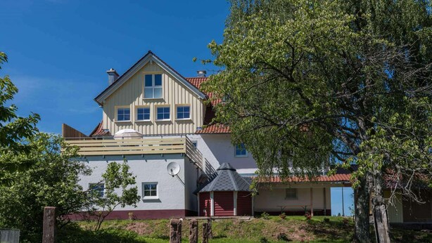 A two-story house with a red roof, a balcony, and a satellite dish. - Exclusive Country house Seewald - quiete area, Whirlpool, Sauna, large garten, bbq, wifi (Seewald)