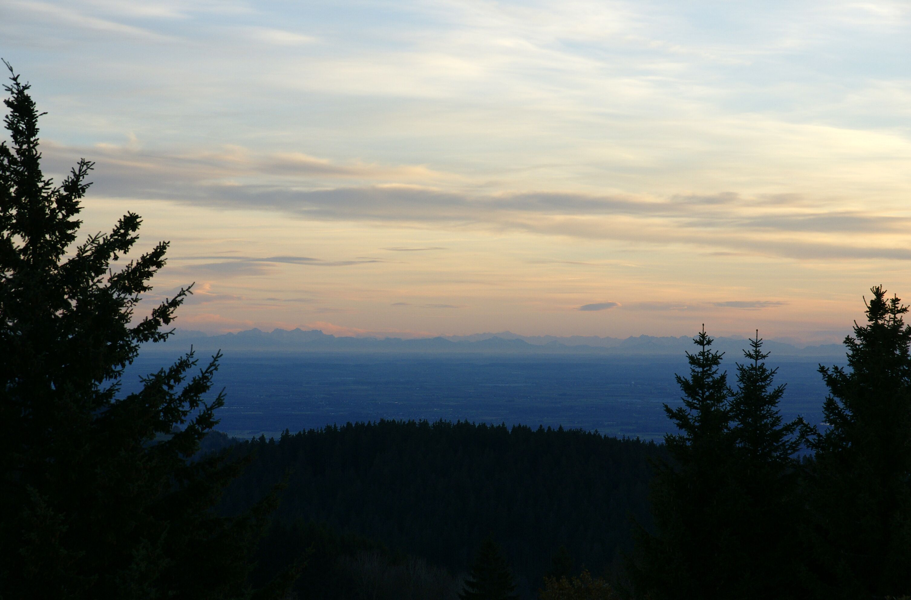Un paysage montagneux, avec une forêt dense et un ciel dégagé.