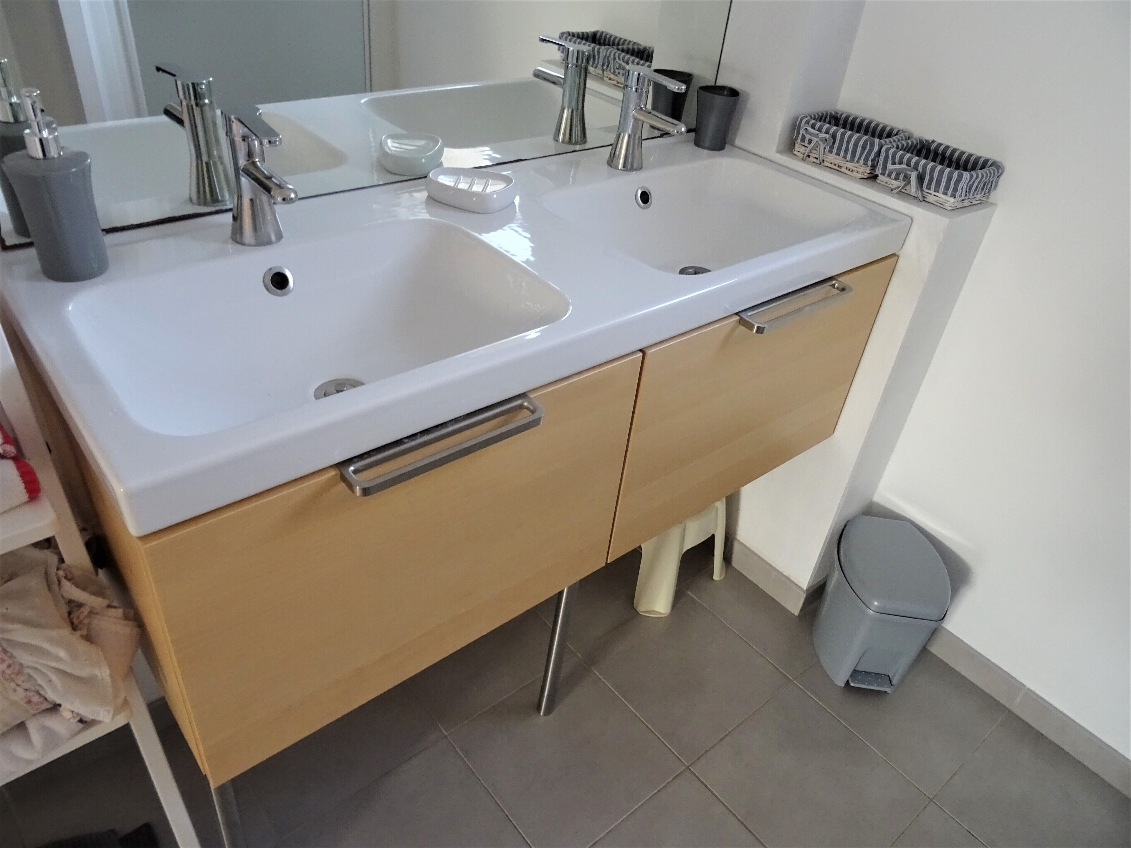 Une salle de bain avec deux lavabos, un miroir et des toilettes.