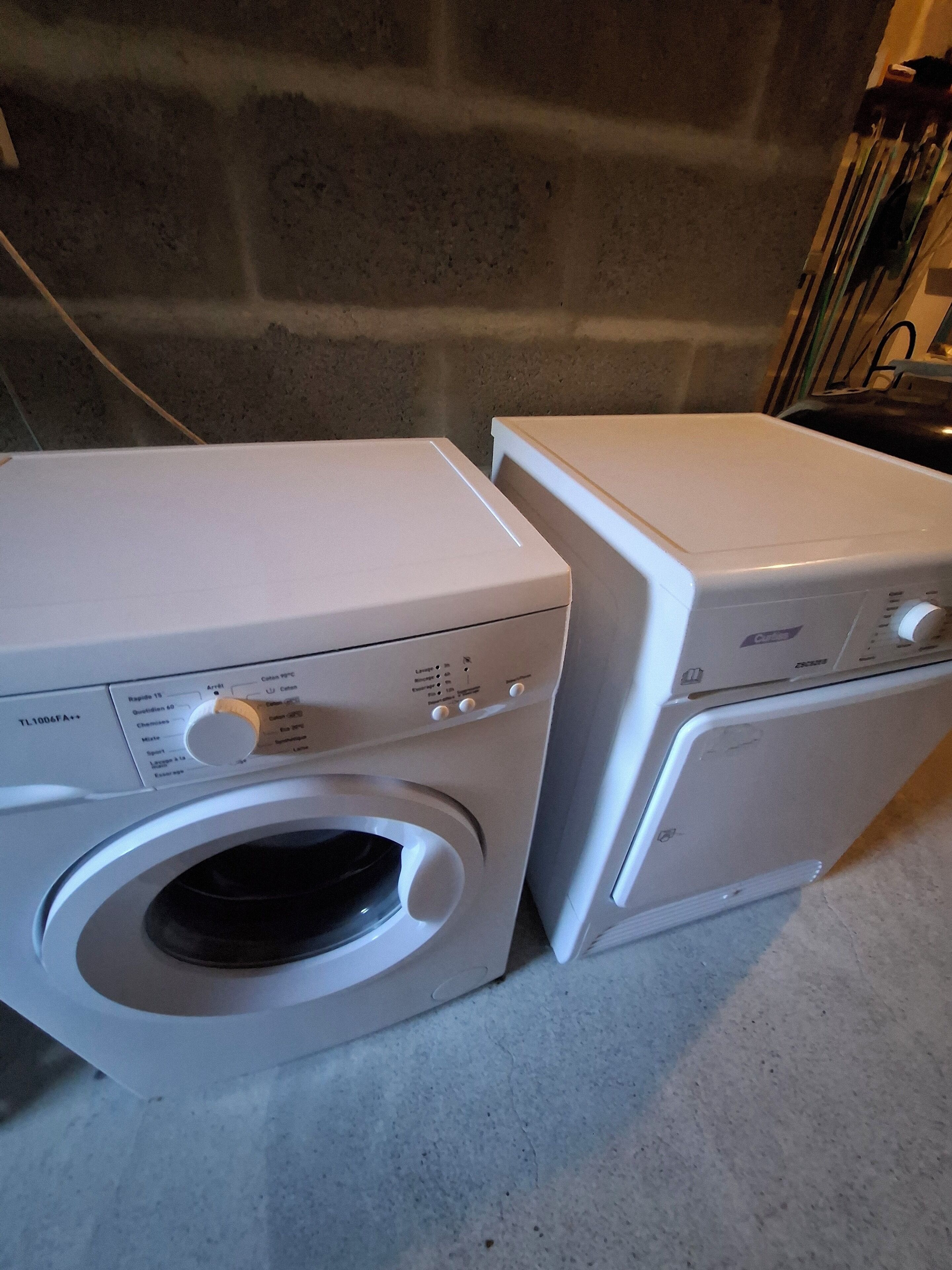 Two stacked white washing machines with control panels and a small window on the front of the lower machine.