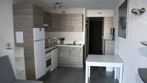 A compact kitchen with modern appliances, a dining table, and a small seating area. - Apartment with balcony at the foot of the slopes - Arc 2000 (Bourg-Saint-Maurice)