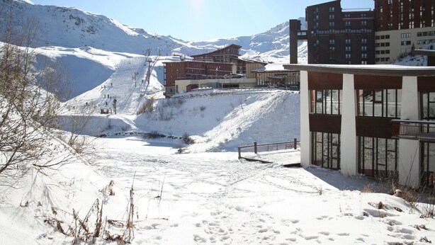 A snow-covered mountain area with buildings, including a hotel with a ski lift in the background. - Apartment with balcony at the foot of the slopes - Arc 2000 (Bourg-Saint-Maurice)