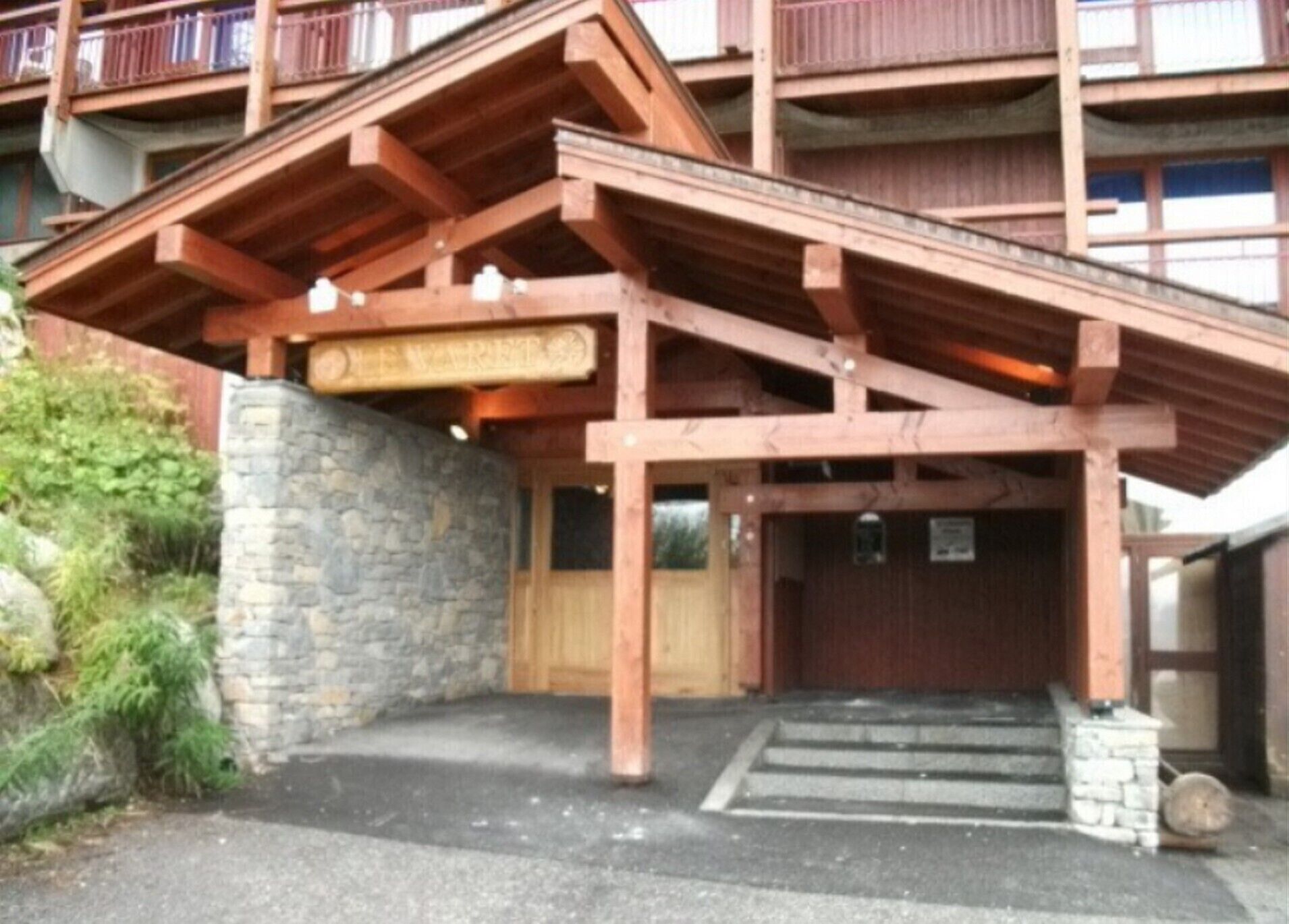 Ein Holzgebäude mit einem Eingang aus Stein und einem Schild mit der Aufschrift "The Village".