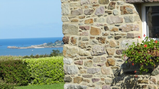 Un bâtiment en pierre doté d’une fenêtre et offrant une vue sur la mer.