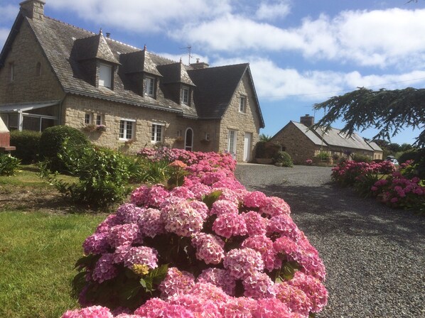 A stone building with a sloped roof and multiple chimneys. - Breton Longere, seaside view, close to the beach, personalized welcome (Paimpol)