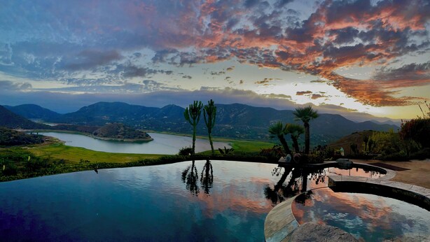 Une piscine avec vue sur les montagnes et un lac.