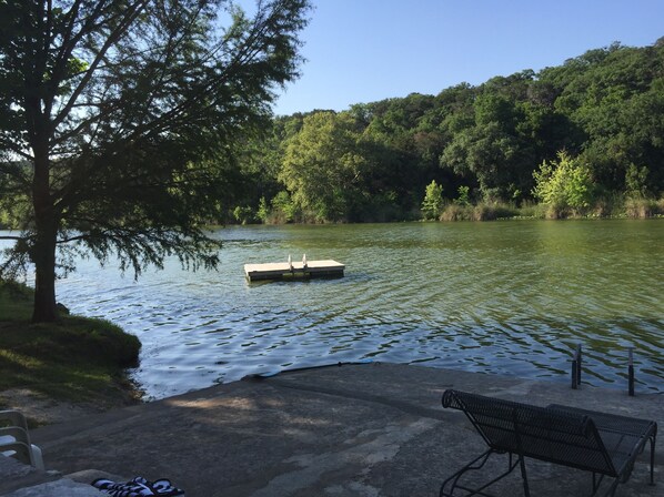 A lakeside bench and a dock extending into the water.