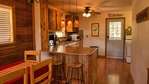 A kitchen with wooden cabinets, a bar area, and a ceiling fan.