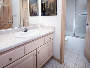 A bathroom with a sink, mirror, cabinet, and a shower area. - Sun Vail 23-e (Vail)