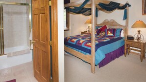 A bedroom with a four-poster bed, a wooden door, a shower, and a bedside table with a lamp. - Sun Vail 14-e (Vail)