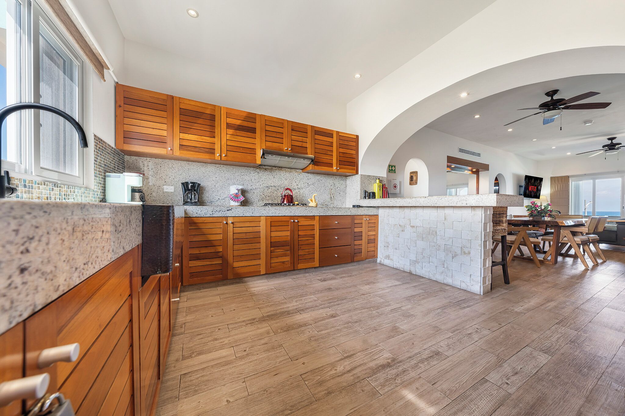 A modern kitchen with wooden cabinets, a granite countertop, and a central island.