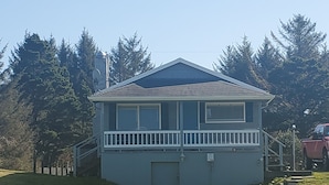 A two-story house with a front porch and a small deck.
