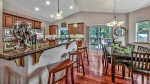 A spacious kitchen with a large island, wooden cabinets, and a dining area with a chandelier. - Quiet Mtn 4BR, 3BA, Spa, Poker, Central AC (South Lake Tahoe)