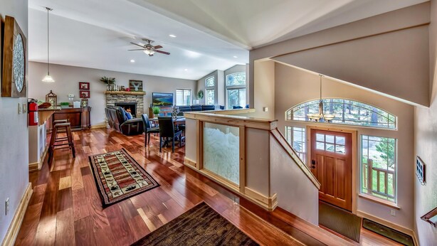A spacious living area with hardwood floors, a fireplace, and a view of the outdoors. - Quiet Mtn 4BR, 3BA, Spa, Poker, Central AC (South Lake Tahoe)