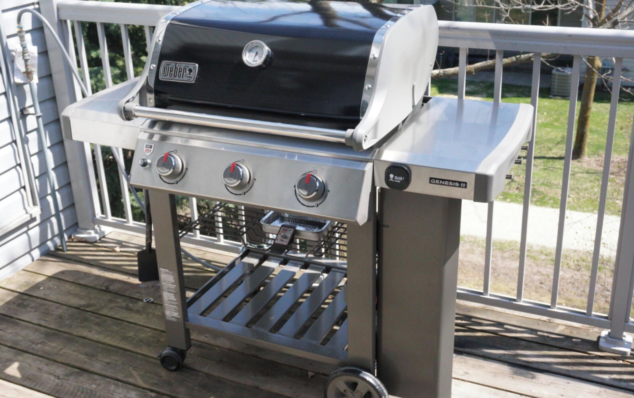 Un barbecue Weber Genesis II portable, doté de trois brûleurs, d’une ouverture de ventilation latérale et d’un thermomètre numérique.