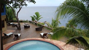 A wooden deck with lounge chairs and a pool, overlooking a body of water. - Mariposa Del Mar: Spectacular Ocean front Villa with private pool. (Roatan)