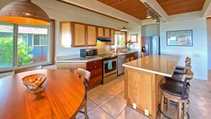 Una cocina moderna con armarios de madera, una isla central y una mesa de comedor.