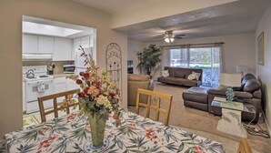 A living room with a sofa, a coffee table, and a dining area with a table and chairs. - Short/Long Stays; Sun, Fun, & Relax in the Gardens.  (Palm Beach garden)