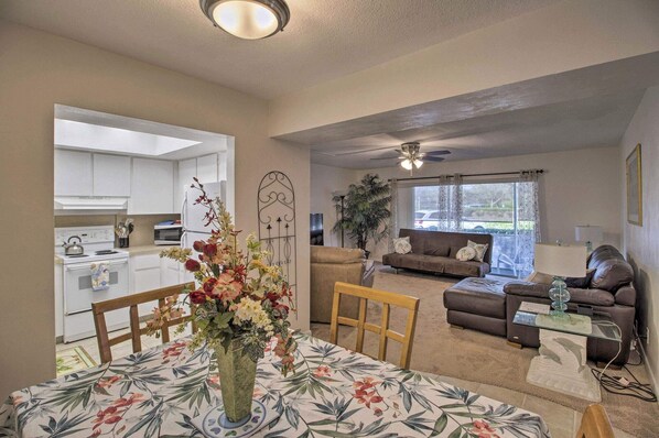 A living room with a sofa, a coffee table, and a dining area with a table and chairs.
