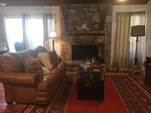 Living room with wood burning fireplace for those cool summer nights.