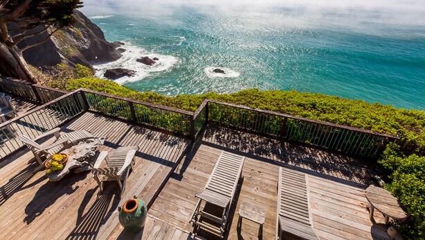 A wooden deck with outdoor furniture overlooking a coastal view. - Oceanfront Vacation Home - Spectacular Views; Hot Tub; Wi-Fi. (Elk)