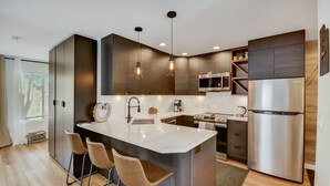 A modern kitchen with a central island, stainless steel appliances, and pendant lighting. - Canyons Hidden Creek Studio on the Duck  Pond (Park City)