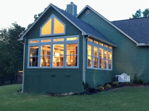 Stunning home with a gabled roof and large bay window, set amidst a beautifully manicured lawn.