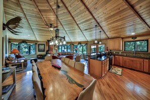 A spacious kitchen with wooden cabinets, a large island, and a dining area with a long table and chairs.