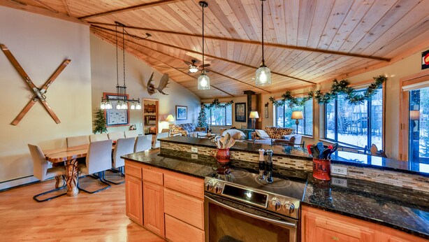 Une cuisine spacieuse avec des meubles en bois, un grand îlot central et un four encastré.