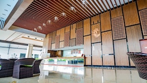 A modern hotel lobby with a wooden ceiling, patterned wall panels, and a reception desk. - Amerald Resort Hotel Desaru (Bandar Penawar)