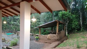 A covered outdoor area with a stone structure, a small pool, and surrounding greenery. - Foret De Vill - Hostel (Ella)