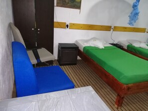 A room with a bed, a chair, a small table, and a wall socket. - Foret De Vill - Hostel (Ella)