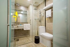 Een moderne badkamer met een douchecabine van glas, een toilet en een wastafel. Aan de muur hangt een handdoek.