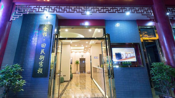 The entrance to Sucha Hotel with a modern design, featuring a neon sign, a reception area, and a glass door. - Sucha Hotel Xian Bell Tower Huimin St (Xi'an)