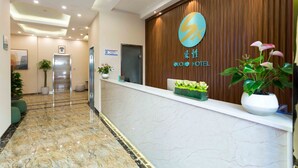 A hotel reception area with a marble floor, wooden paneling, and potted plants. - Sucha Hotel Xian Bell Tower Huimin St (Xi'an)