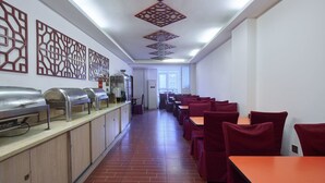 A cafeteria with a long counter, multiple seating areas, and decorative ceiling panels. - Sucha Hotel Chongqing N. Railway Station (Chongqing)